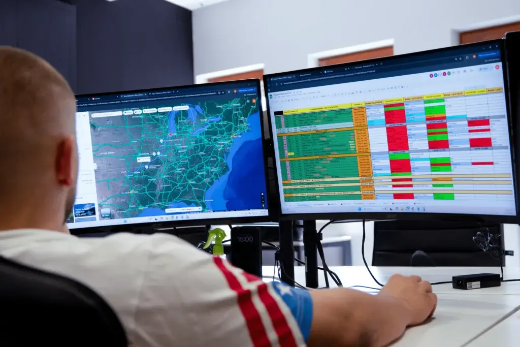 Dispatcher monitoring box truck routes and schedules on dual screens