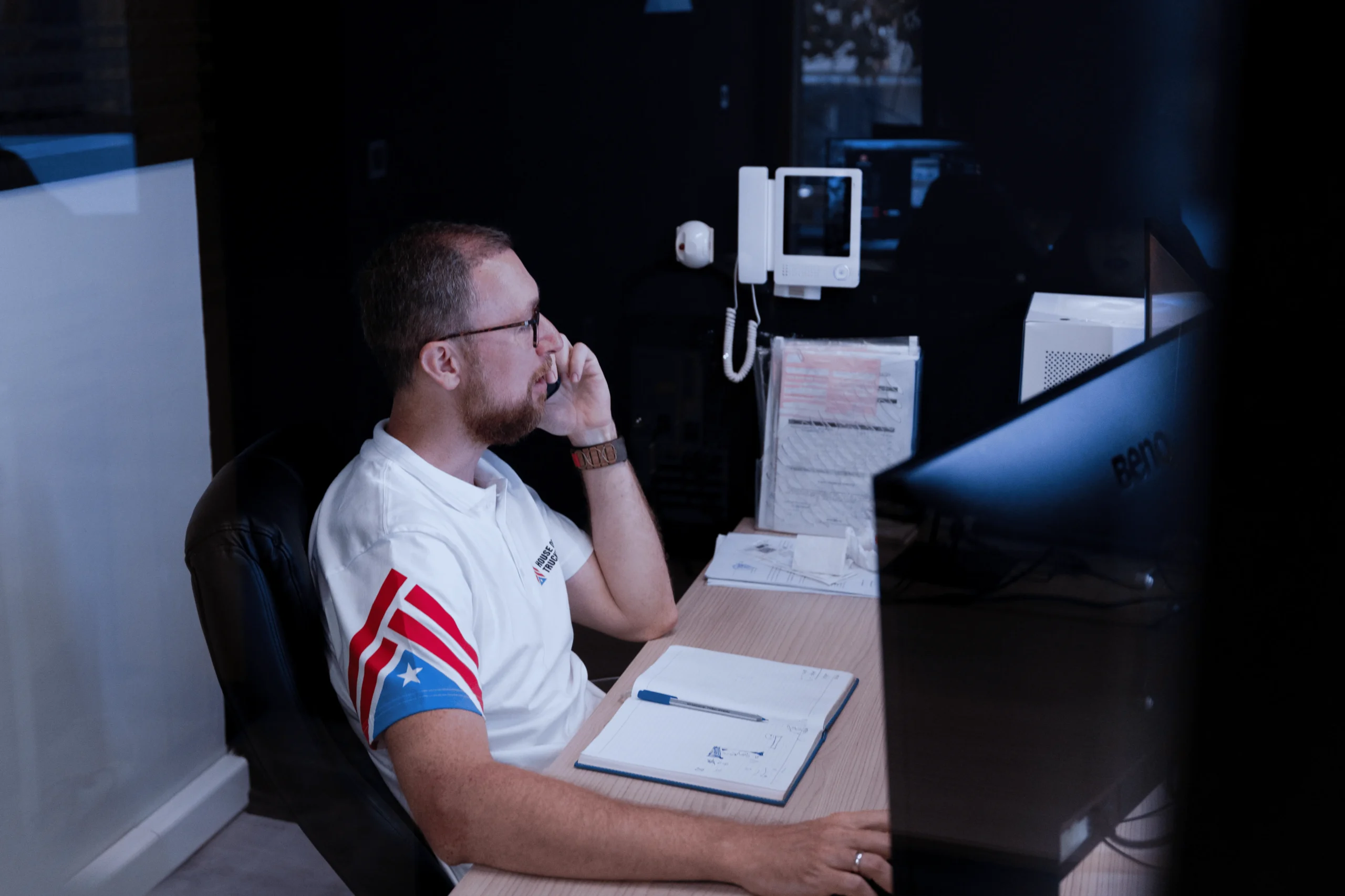 House of Trucking compliance officer on a phone call at desk