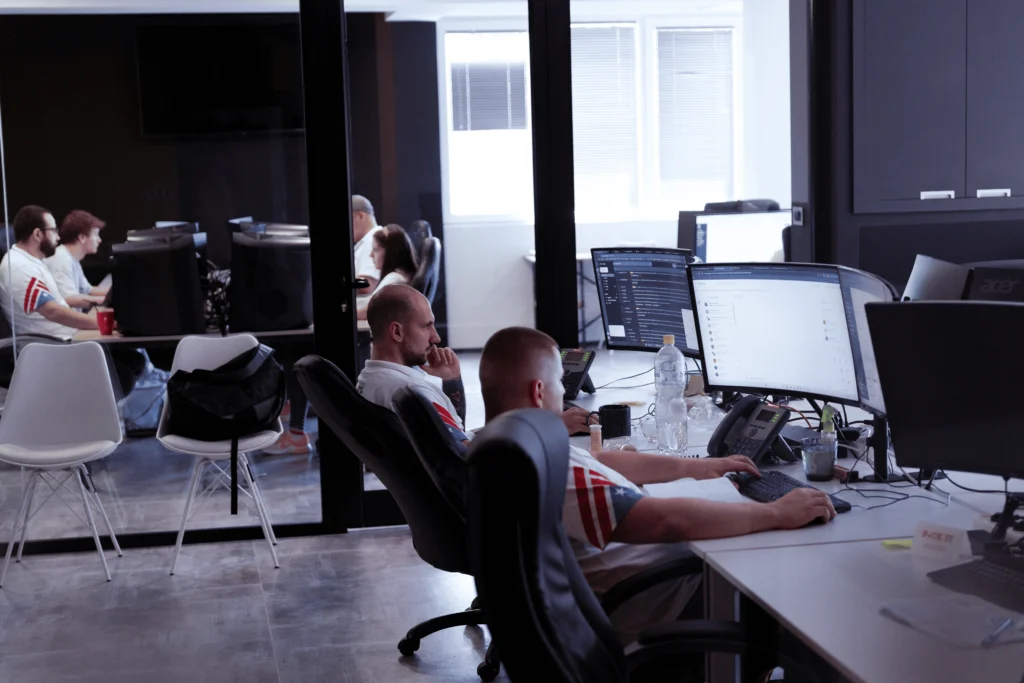 House of Trucking dispatch team collaborating in the office with multiple monitors