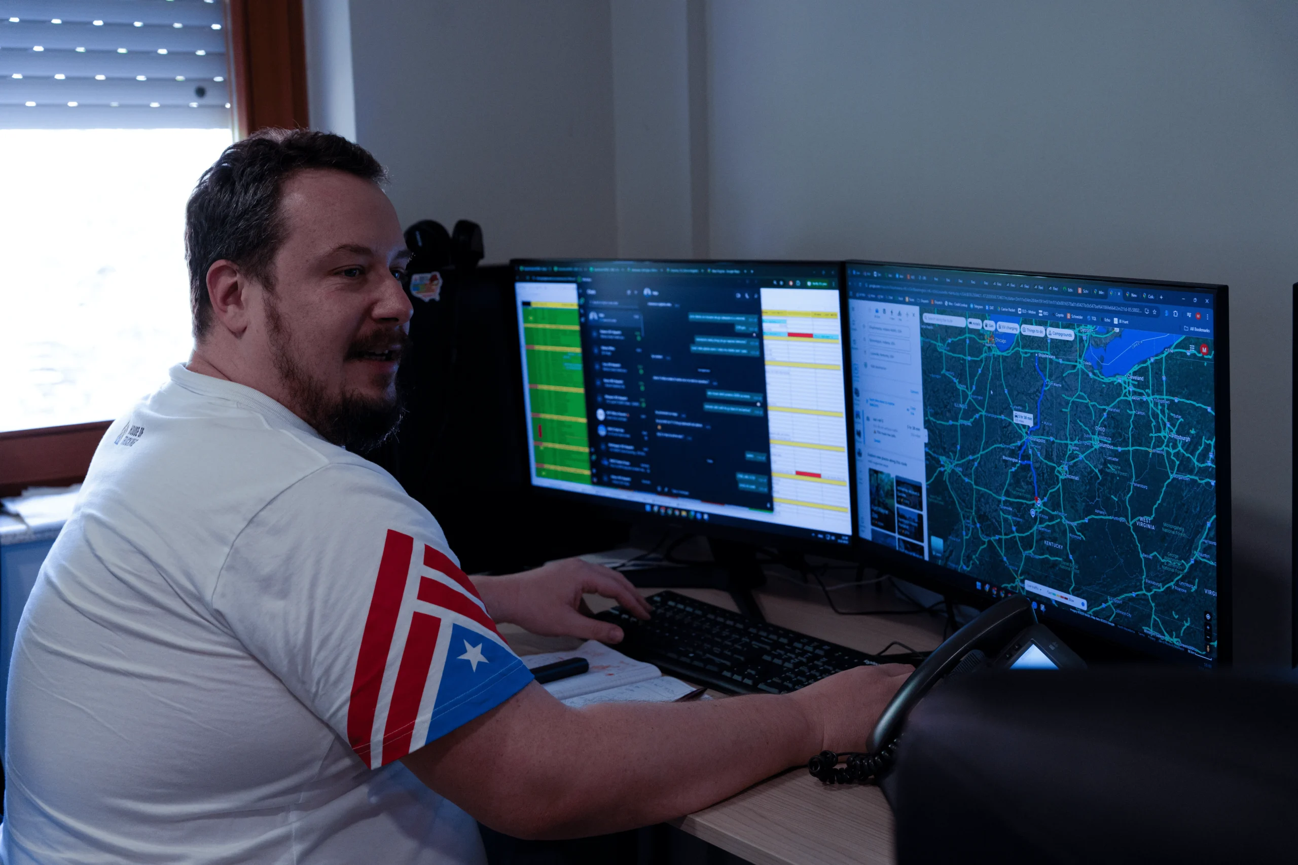 House of Trucking dispatcher monitoring routes and loads on dual screens