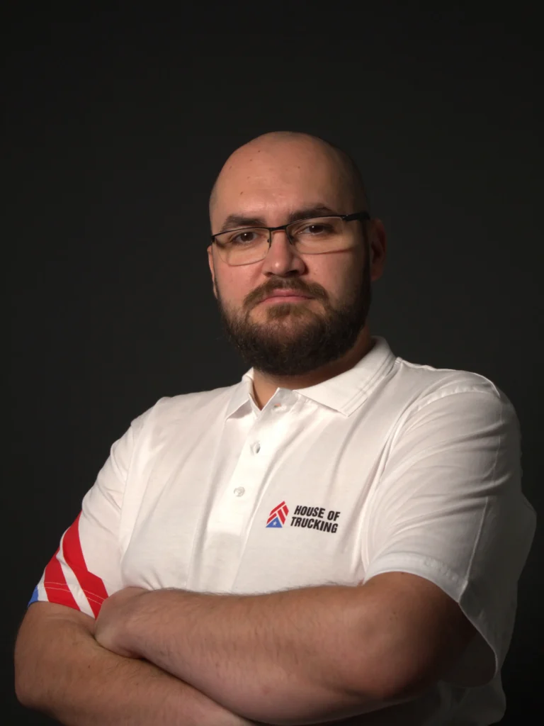 Eddie, Senior Prime Dispatcher at House of Trucking, wearing the official company polo shirt.