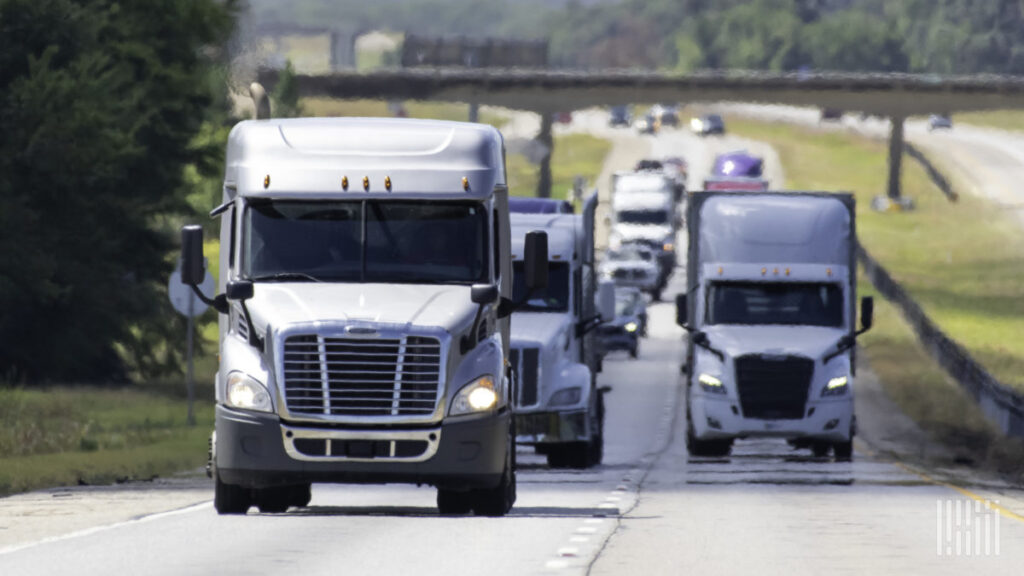 Fleet of semi-trucks driving on highway representing local dispatch services